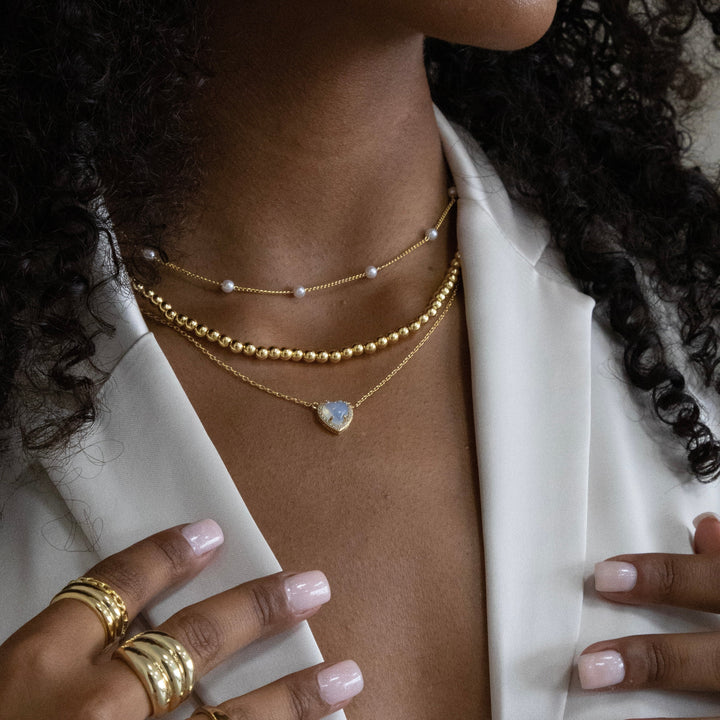 Gold initial letter pendant necklace on fine polished chain