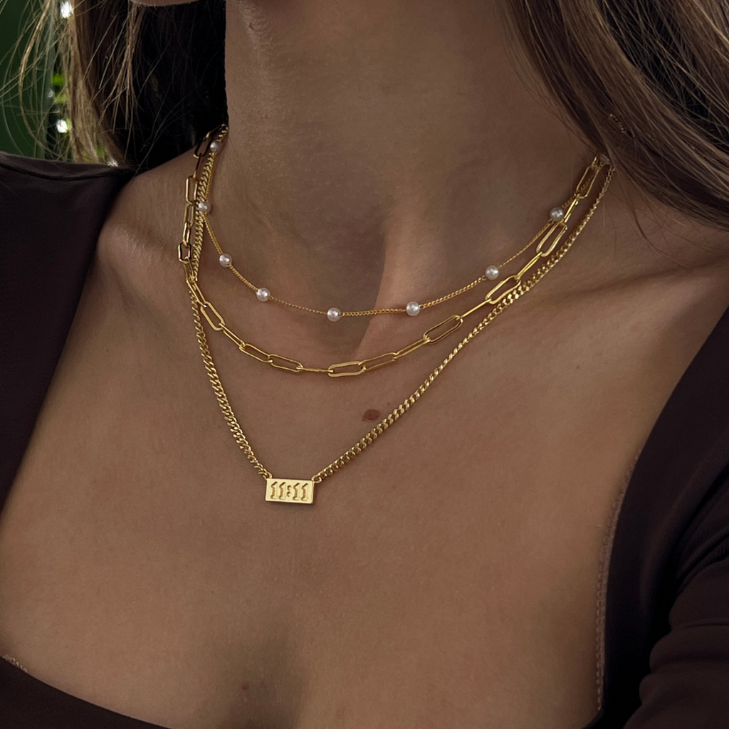 Gold initial letter pendant necklace on fine polished chain