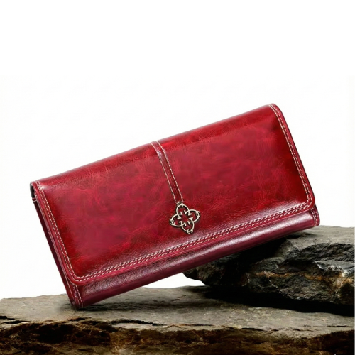 A woman holding an open bifold wallet, tucking a card into its slot.