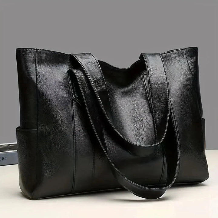 A woman carrying a classic elegant bag with a rich finish over her shoulder