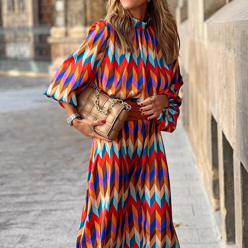 Woman in the Daisy geometric print maxi dress with a high neckline and puff sleeves, walking through a city street.