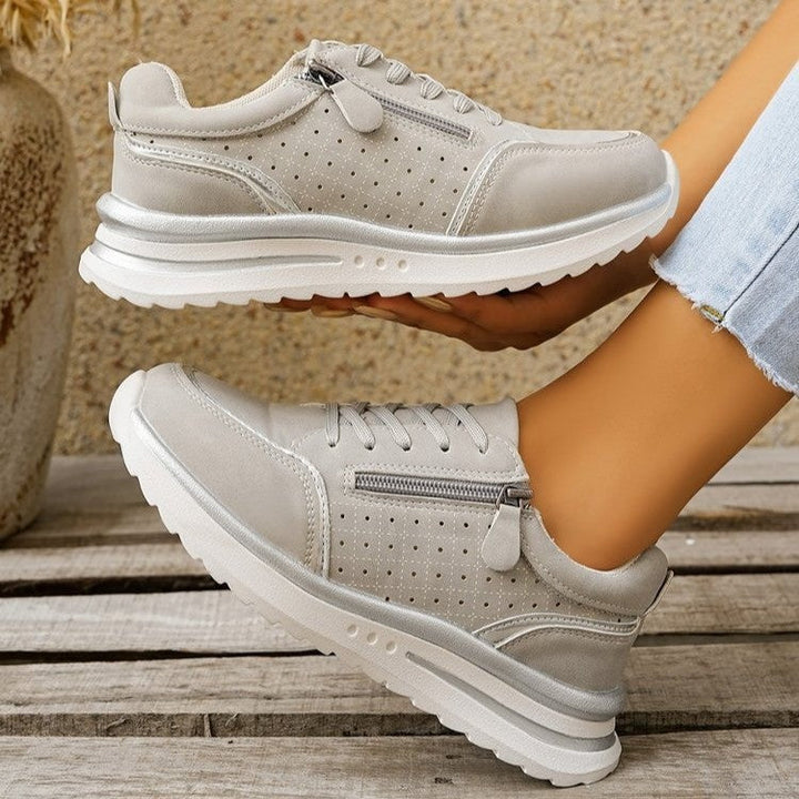 A woman standing comfortably in orthopaedic arch support trainers.