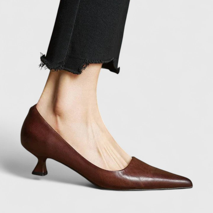 A woman in classic black pointed-toe comfort heels moving easily from office to evening.