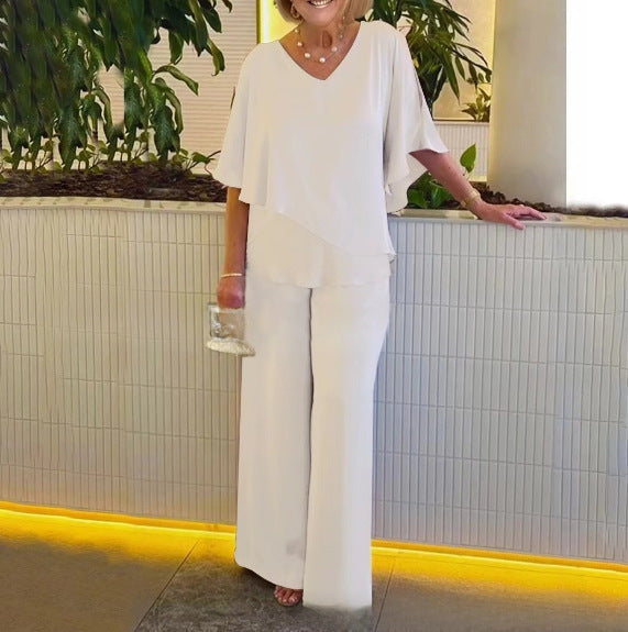 A woman wearing an asymmetric flowing top with matching wide-leg trousers.