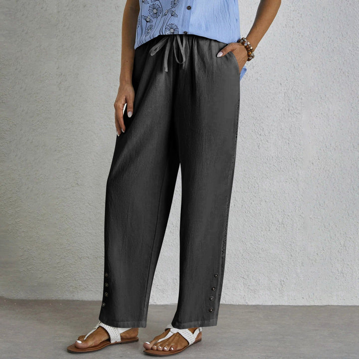 Woman wearing relaxed button-detail trousers with a simple top, out for the day.