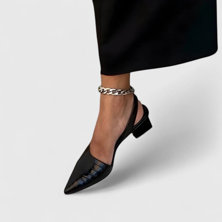 A woman wearing elegant low-heel dress sandals with an adjustable strap at a special occasion.
