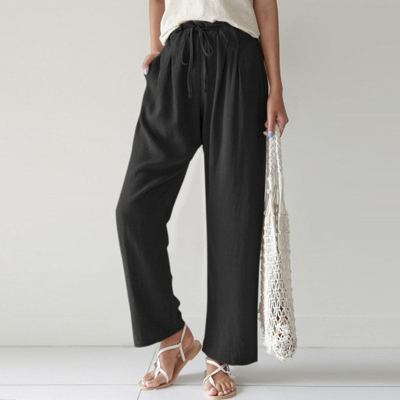 A woman walking outdoors in relaxed drawstring trousers with an easy, comfortable everyday look.