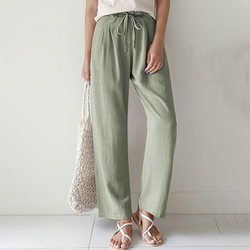 A woman walking outdoors in relaxed drawstring trousers with an easy, comfortable everyday look.