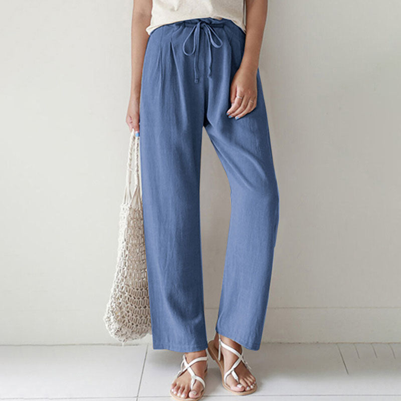 A woman walking outdoors in relaxed drawstring trousers with an easy, comfortable everyday look.