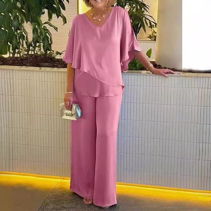 A woman wearing an asymmetric flowing top with matching wide-leg trousers.
