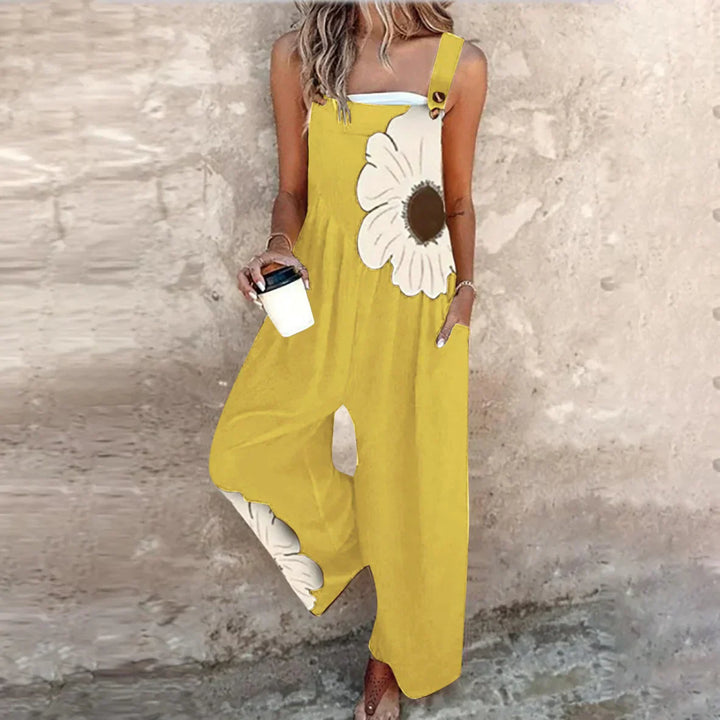 A woman wearing elegant black dungarees with a single large cream bloom and adjustable straps.