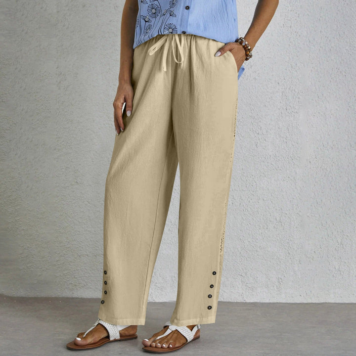 Woman wearing relaxed button-detail trousers with a simple top, out for the day.