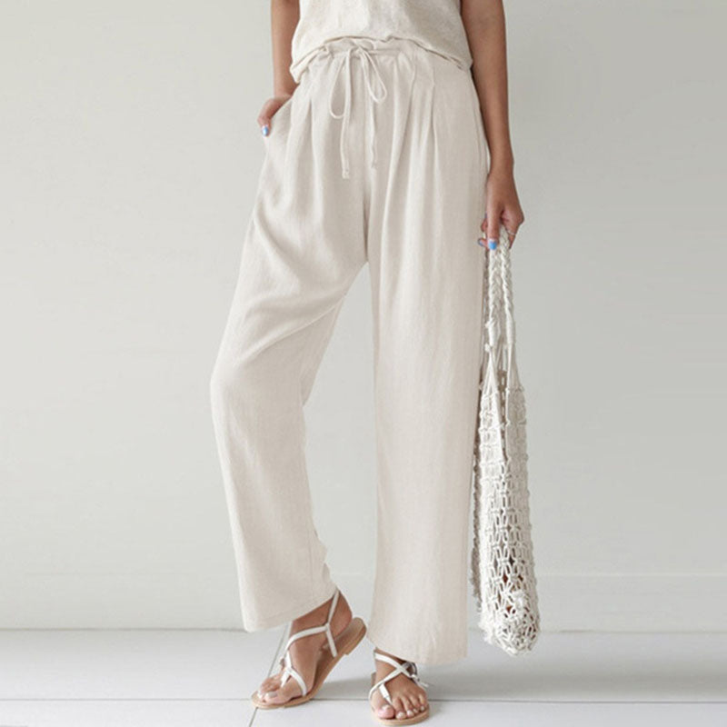 A woman walking outdoors in relaxed drawstring trousers with an easy, comfortable everyday look.