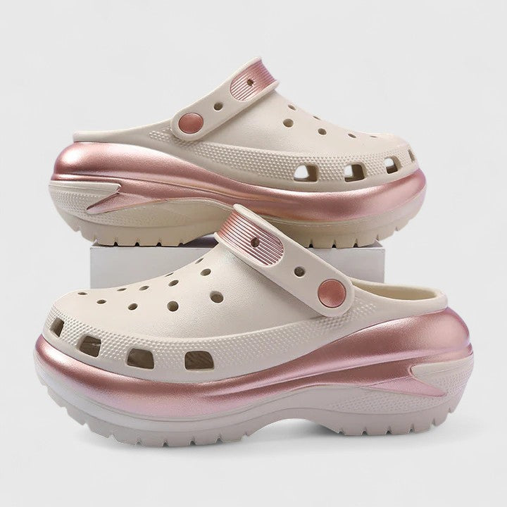 A woman walking comfortably outdoors wearing soft, cushioned orthopaedic clogs with a gentle metallic sheen.