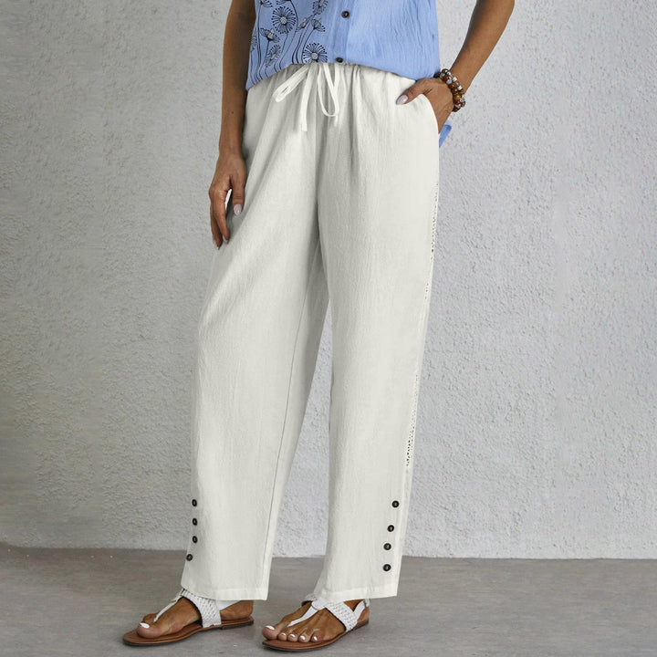 Woman wearing relaxed button-detail trousers with a simple top, out for the day.