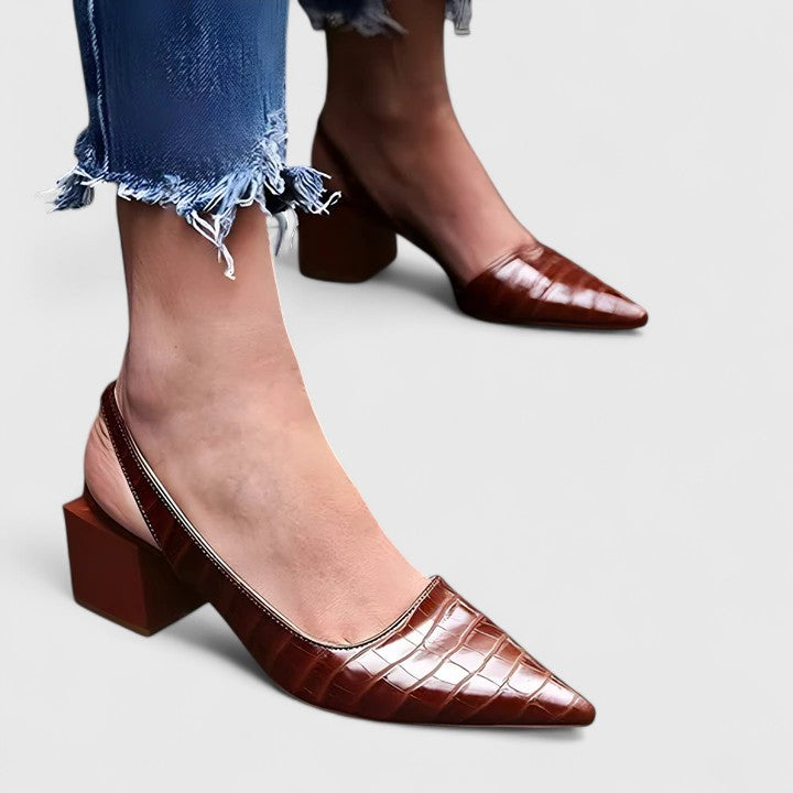 A woman wearing elegant low-heel dress sandals with an adjustable strap at a special occasion.
