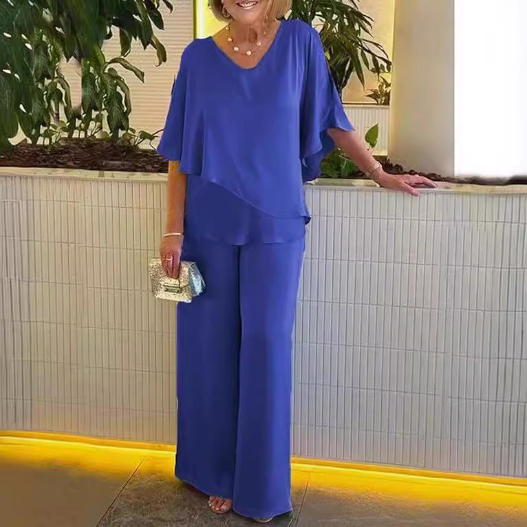A woman wearing an asymmetric flowing top with matching wide-leg trousers.