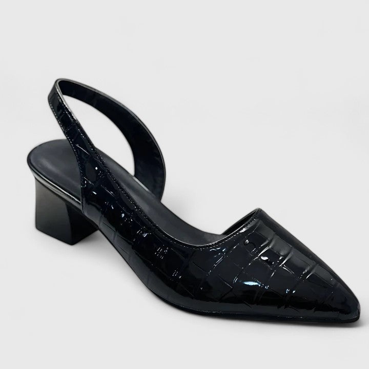 A woman wearing elegant low-heel dress sandals with an adjustable strap at a special occasion.