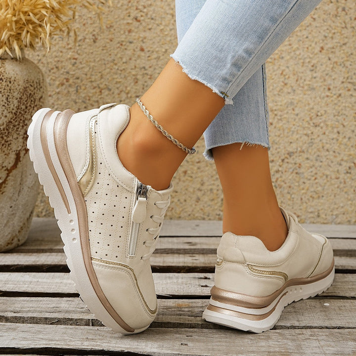 A woman standing comfortably in orthopaedic arch support trainers.