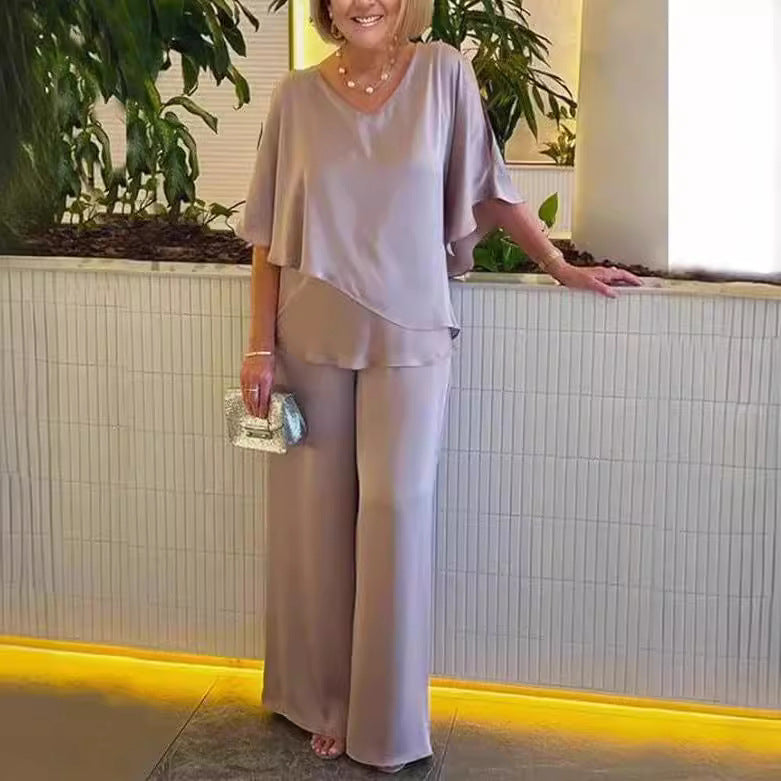 A woman wearing an asymmetric flowing top with matching wide-leg trousers.