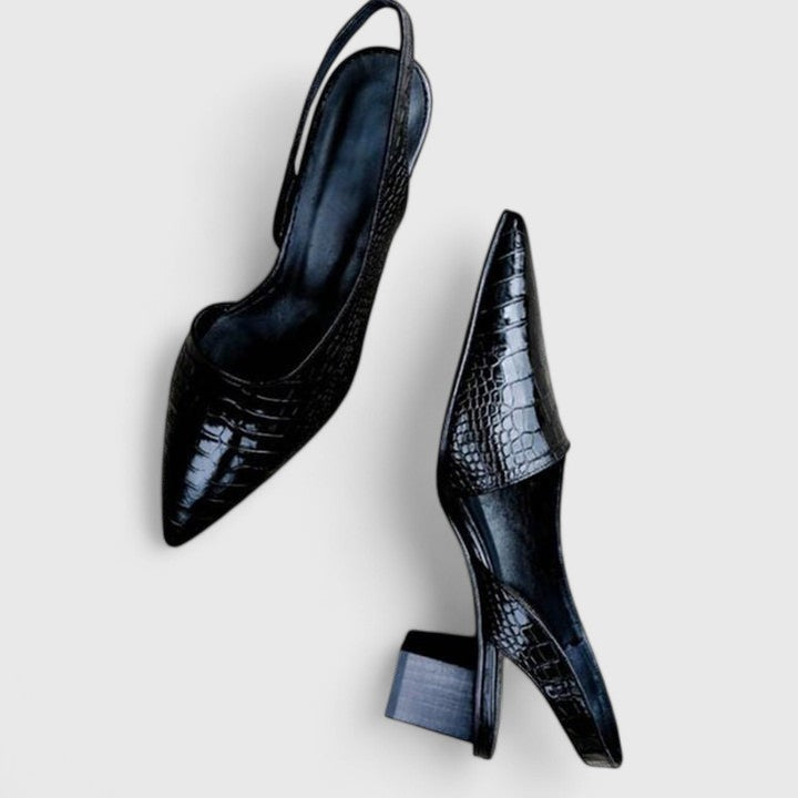 A woman wearing elegant low-heel dress sandals with an adjustable strap at a special occasion.