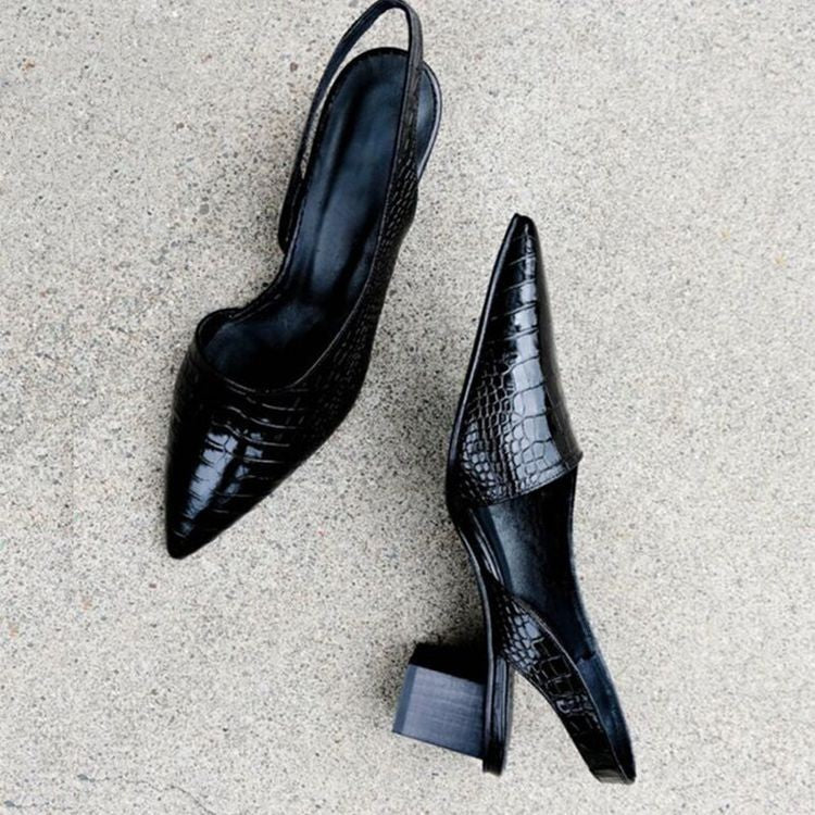 A woman wearing black comfort block heels with a roomy toe box and cushioned sole.