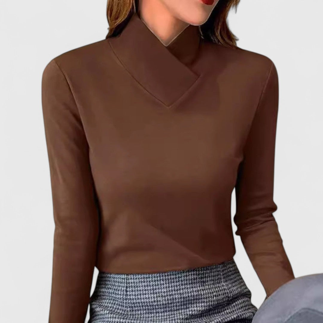 A woman wearing an elegant stand-collar jumper, slim and refined with a flattering line.