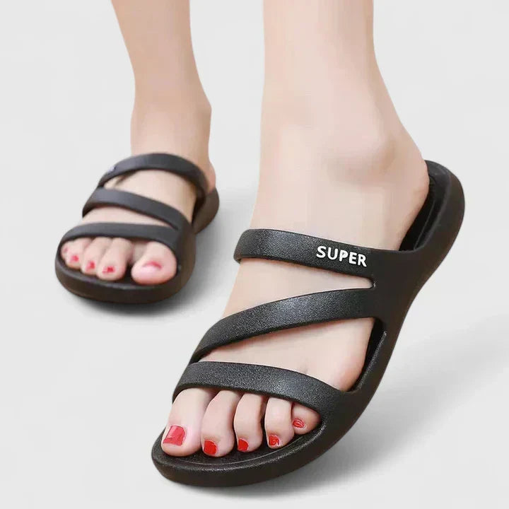 A woman walking confidently outdoors in supportive, cushioned orthopaedic sandals.
