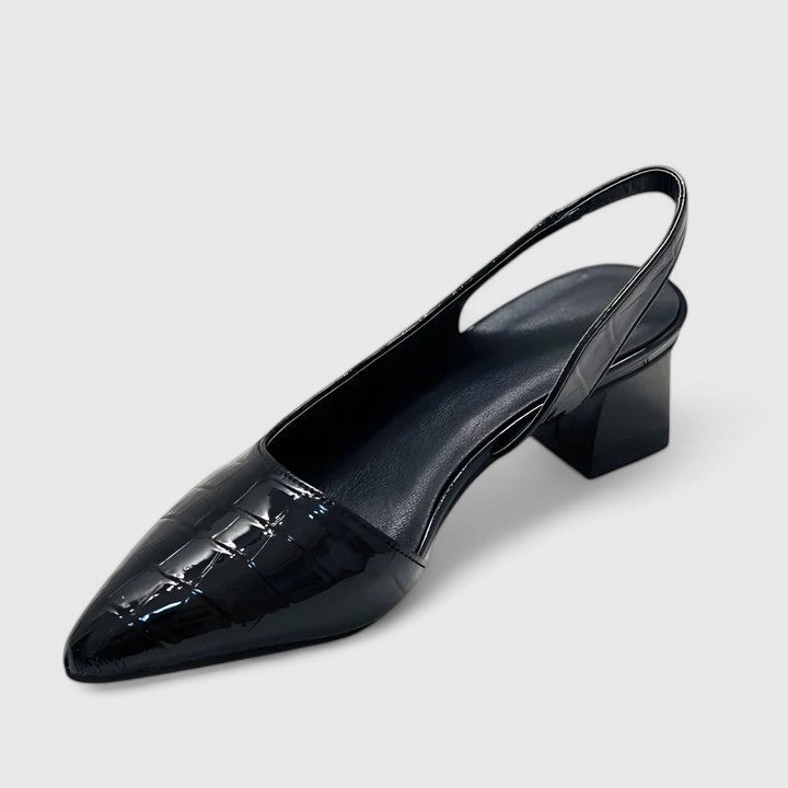 A woman wearing elegant low-heel dress sandals with an adjustable strap at a special occasion.