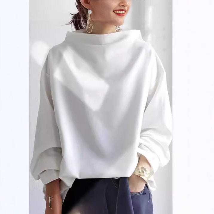 A woman wearing a soft funnel neck jumper styled with jeans for a relaxed elegant look.