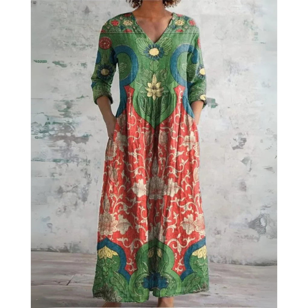 A woman wearing the Assumpta vintage floral maxi dress with a gathered waist and flowing skirt at an outdoor celebration.