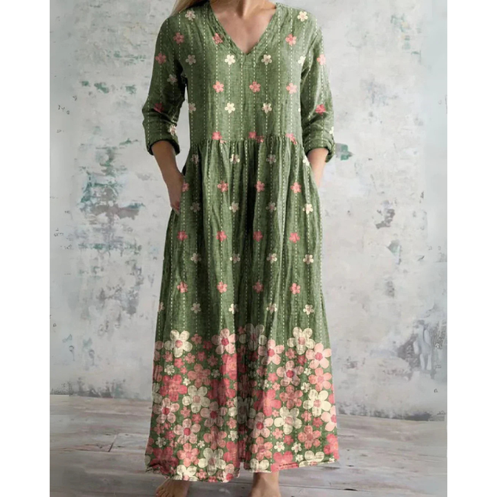 A woman wearing the Assumpta vintage floral maxi dress with a gathered waist and flowing skirt at an outdoor celebration.
