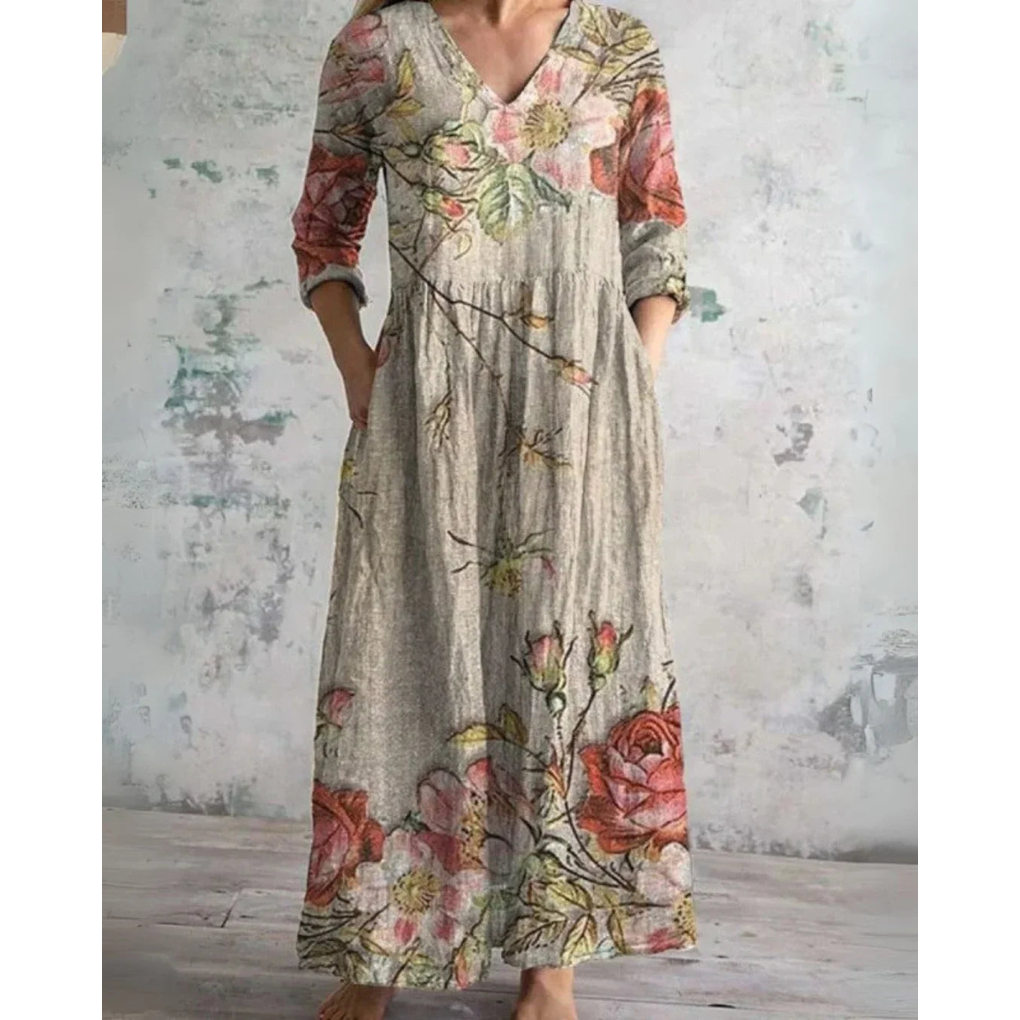 A woman wearing the Assumpta vintage floral maxi dress with a gathered waist and flowing skirt at an outdoor celebration.