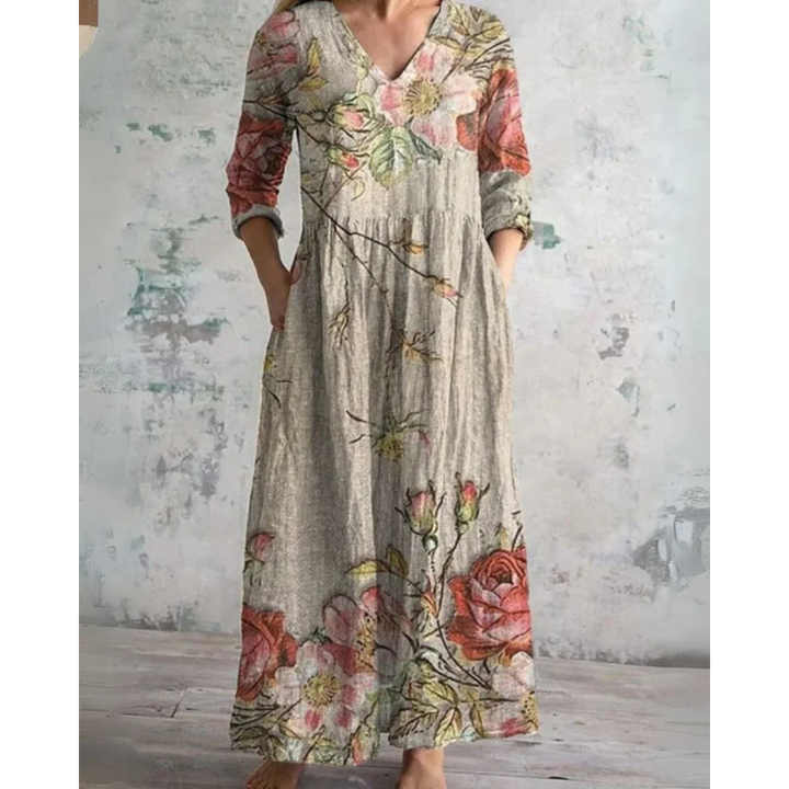 A woman wearing the Assumpta vintage floral maxi dress with a gathered waist and flowing skirt at an outdoor celebration.