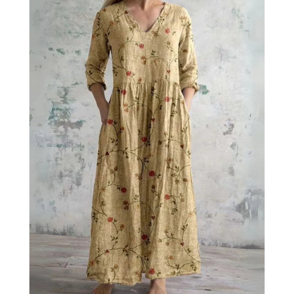 A woman wearing the Assumpta vintage floral maxi dress with a gathered waist and flowing skirt at an outdoor celebration.
