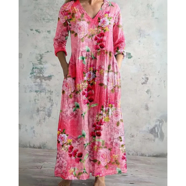 A woman wearing the Assumpta vintage floral maxi dress with a gathered waist and flowing skirt at an outdoor celebration.