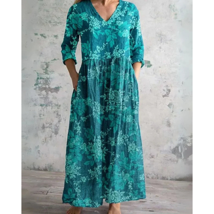 A woman wearing the Assumpta vintage floral maxi dress with a gathered waist and flowing skirt at an outdoor celebration.