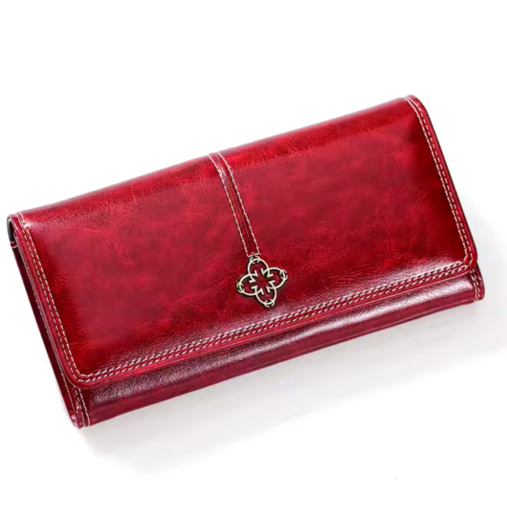 A woman holding a long flap-over wallet, tucking a card into its slot.