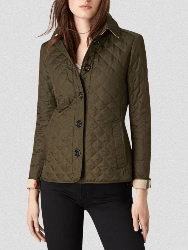A woman wearing an autumn jacket over a top, layered for a crisp day in town.