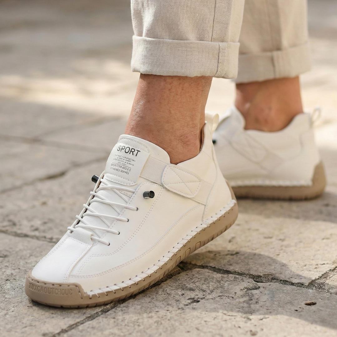 A woman wearing white lace-up orthopaedic trainers with an adjustable strap.