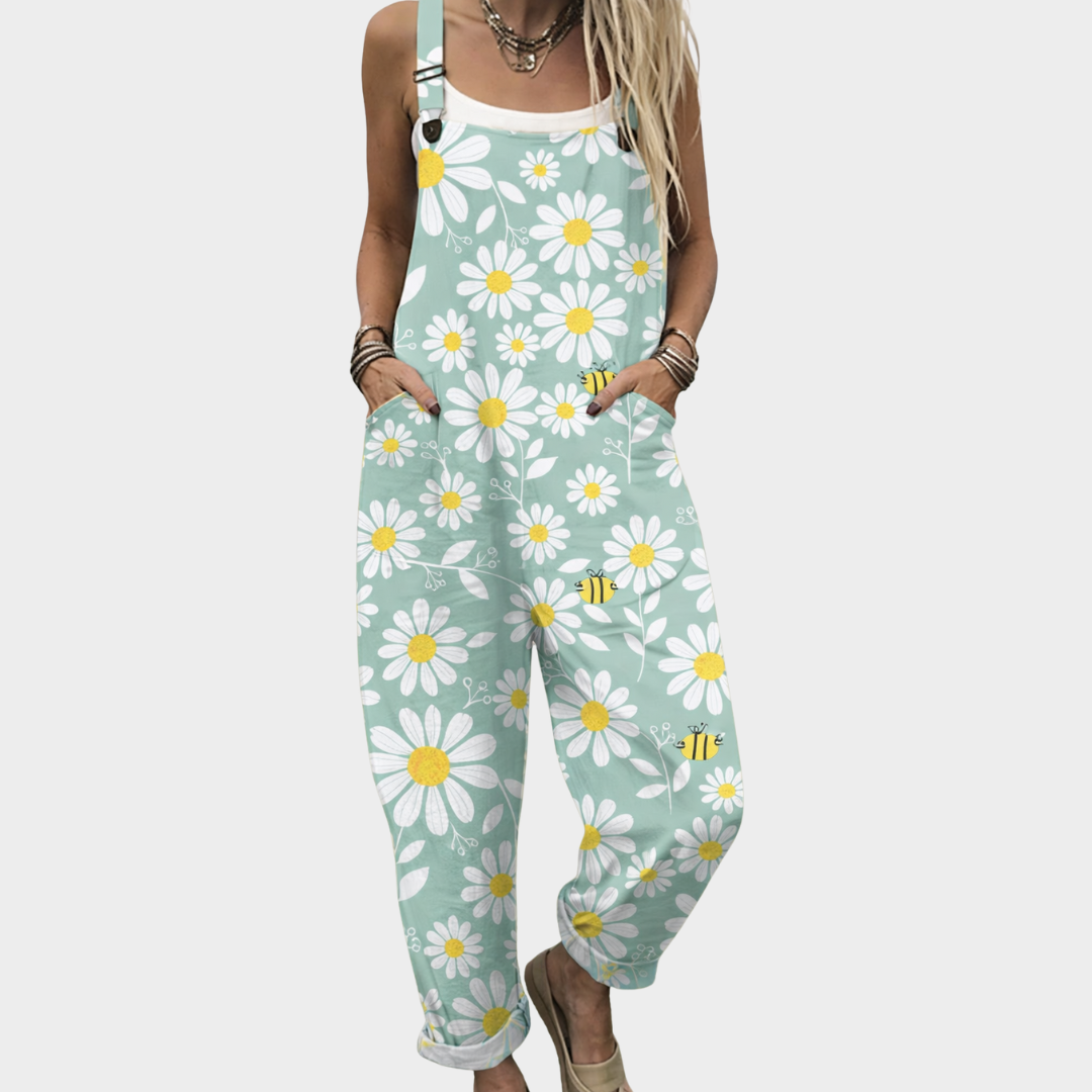 Woman wearing mint green dungarees with a white daisy and bee print, adjustable straps, cheerful and relaxed.