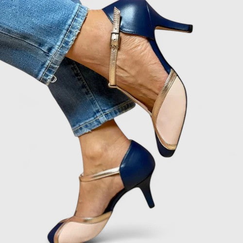 A woman wearing caramel T-strap heels, walking with grace and confidence.