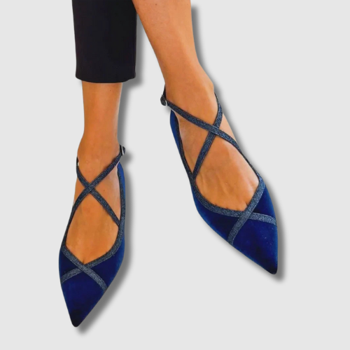 A woman wearing smart navy loafers with tailored trousers, looking elegant and at ease.