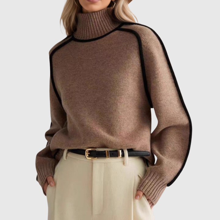 A woman wearing a funnel neck jumper with contrast piping, styled with trousers for a smart-casual look.