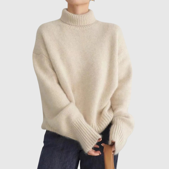 A woman wearing a beige roll-neck jumper, relaxed and warm, paired with trousers.