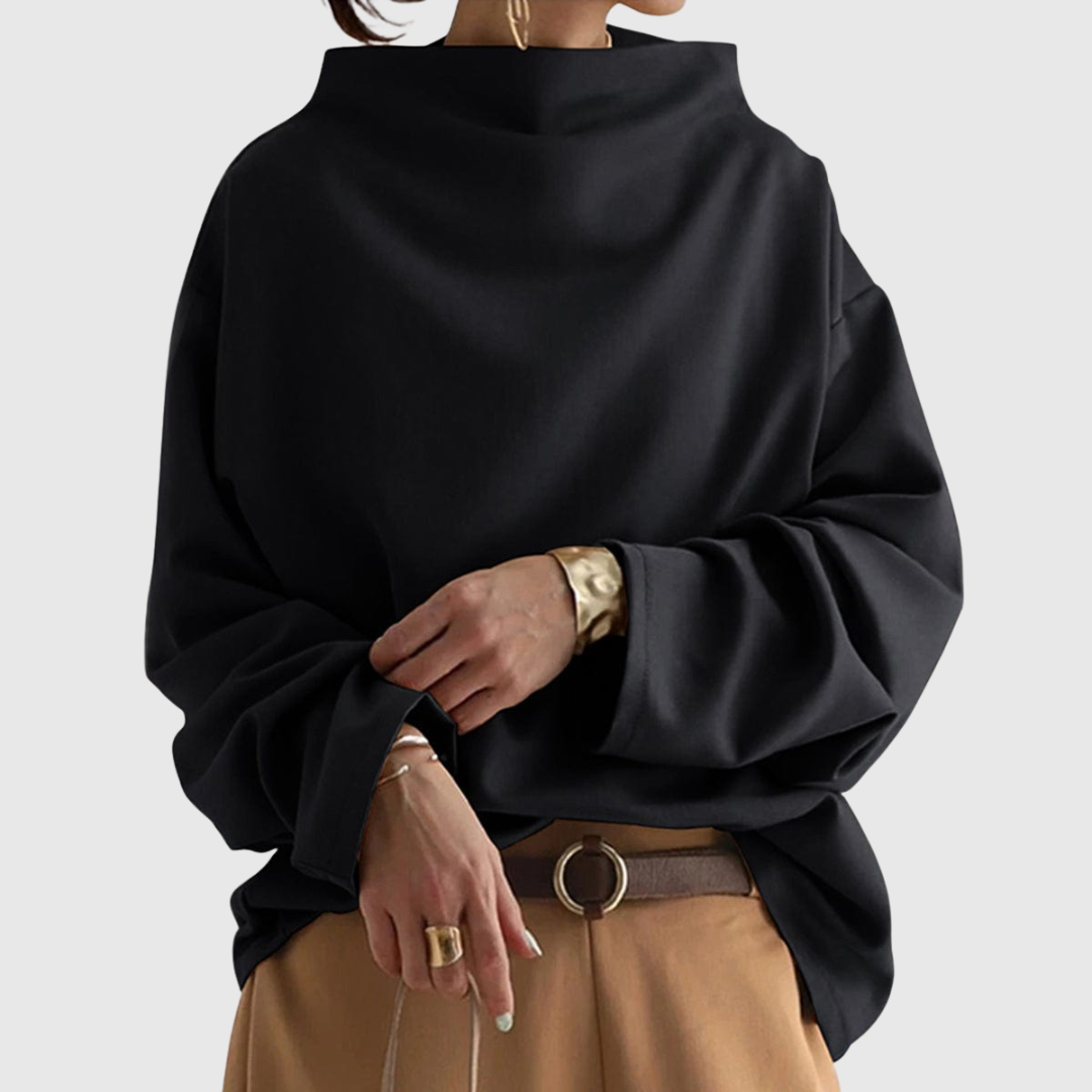 A woman wearing a soft funnel neck jumper styled with jeans for a relaxed elegant look.