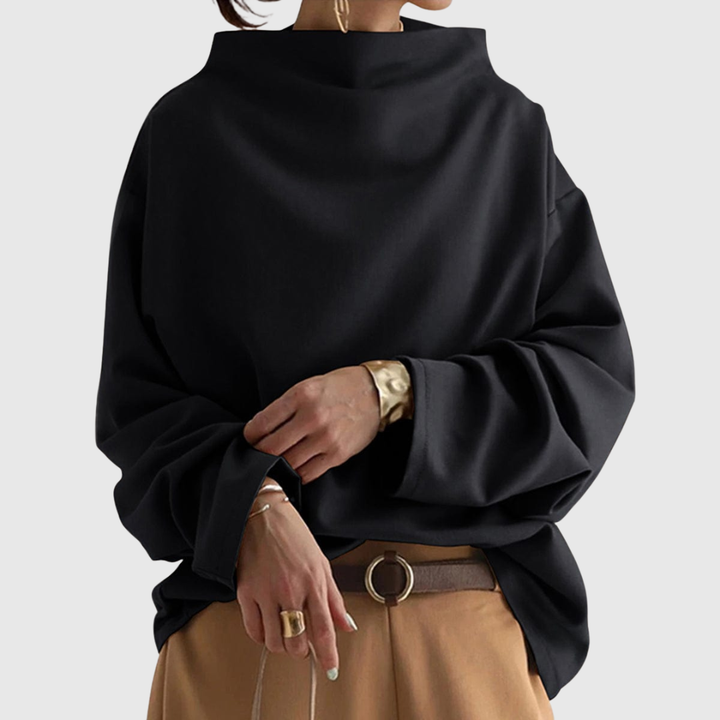 A woman wearing a soft funnel neck jumper styled with jeans for a relaxed elegant look.
