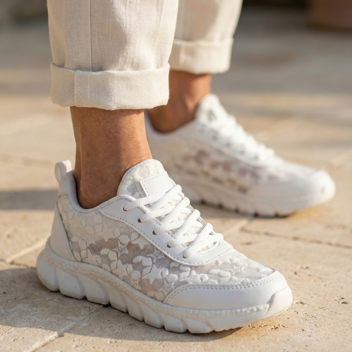 A woman wearing clean white cushioned comfort trainers