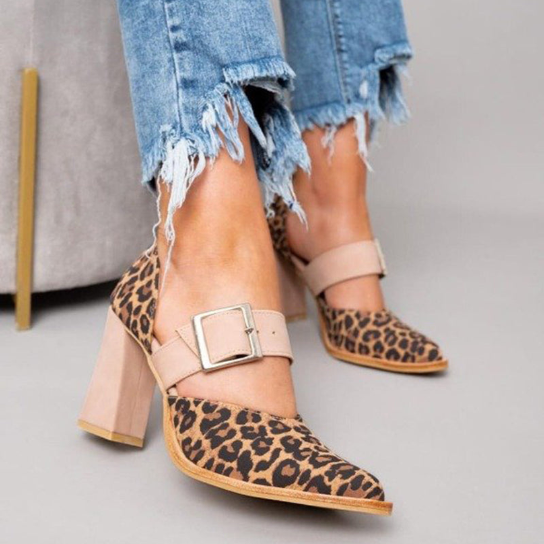 A woman wearing pointed khaki heels, stepping out in a polished day-to-evening outfit.