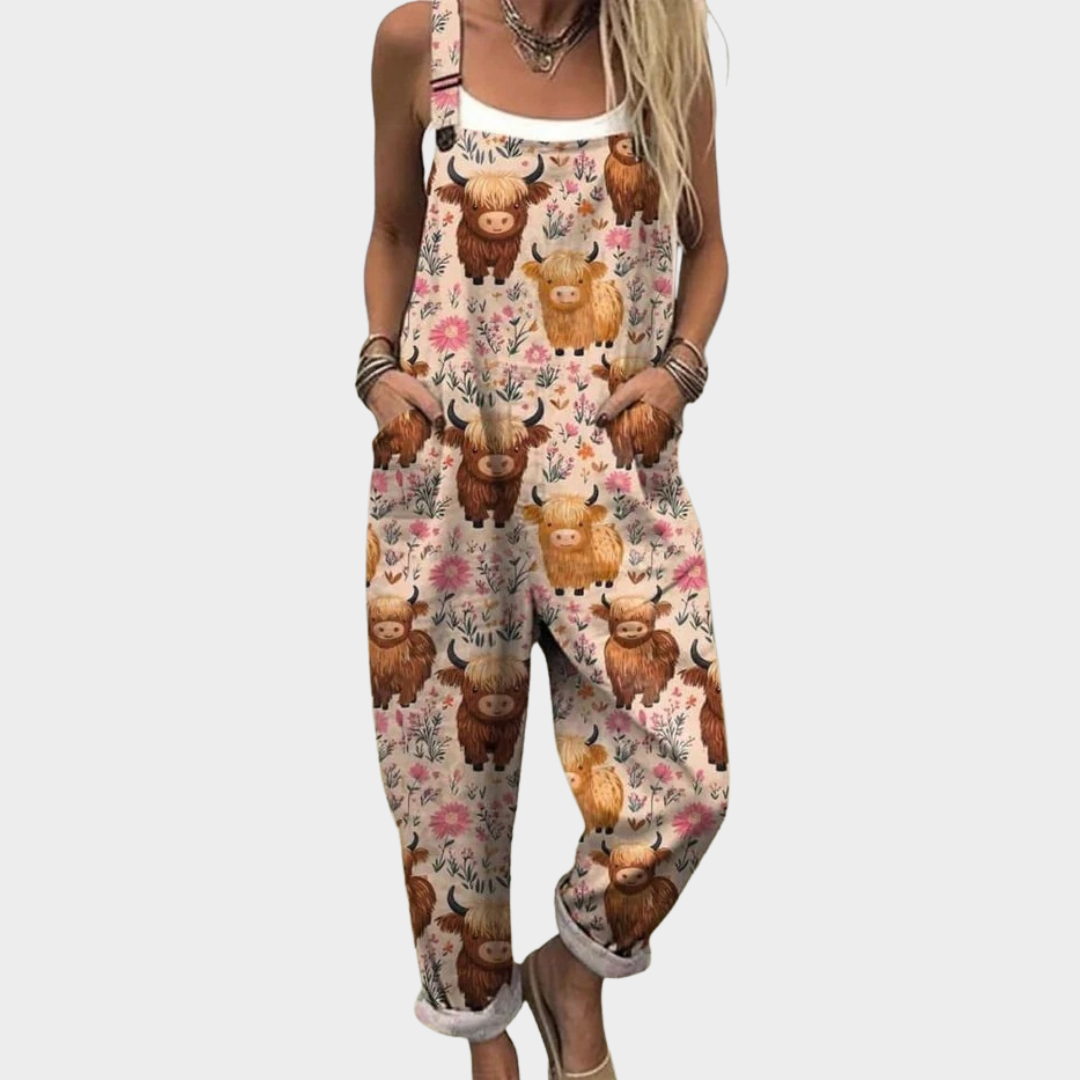 Woman wearing cream dungarees with a Highland cow and floral print, adjustable straps, cheerful and relaxed.